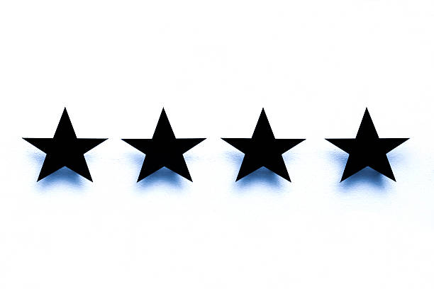 istock Four black stars against with shadows, white background, copy space 525326633