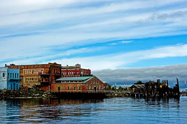 Waterman-Katz building and other old-time buildings on along the pier in Port Townsend, Washington and wispy clouds in the background