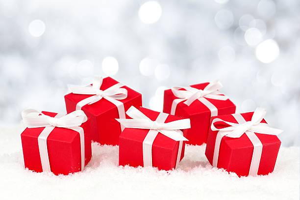 istock Red gift boxes in snow with twinkling lights 525327201