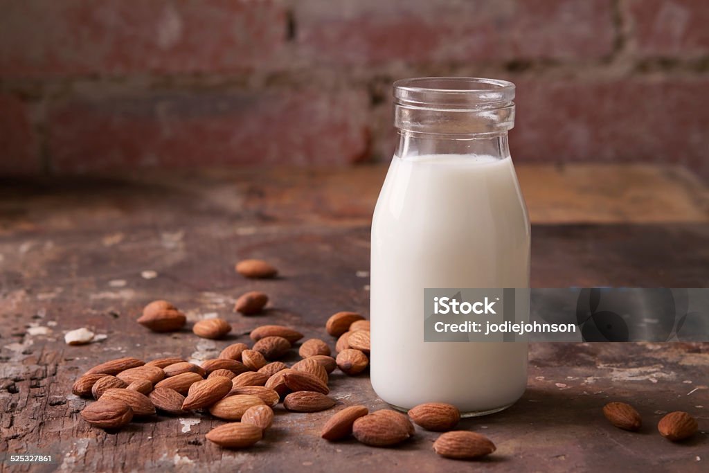 Almond milk in a glass jar with almonds Almond milk in a glass jar with almonds on rustic background Milk Stock Photo