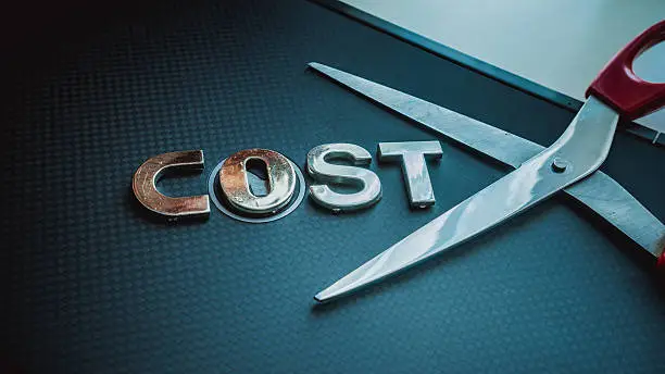 Photo of Stainless steel scissor next to word cost. Concept of cost-cutting