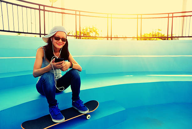 istock woman skateboarder listening music 525331123