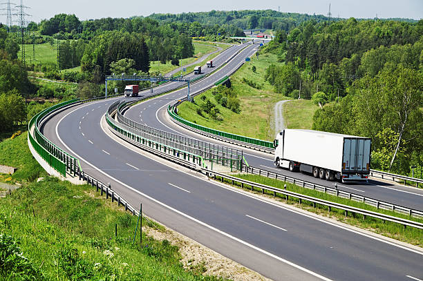 istock The highway between woods, electronic toll gates, moving trucks 525331907