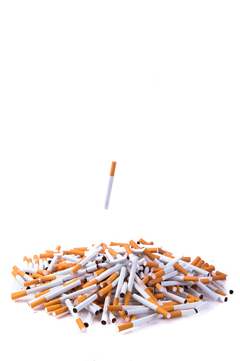 Stop Smoking!  throw a cigarette into a pile of cigarettes against white background.