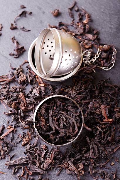 istock Tea strainer full of dry tea leaves on slate stone 525337278