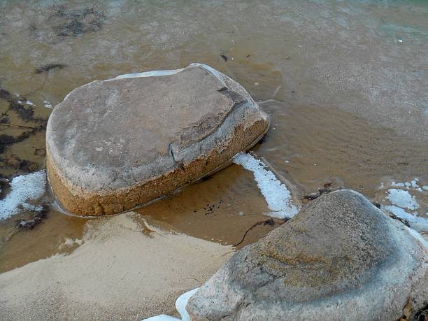 istock Two stones frozen lake shore 525339873