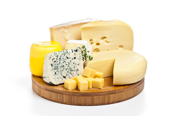 Cheese tray Various types of cheese on round wooden tray isolated on white background cheese stock pictures, royalty-free photos & images
