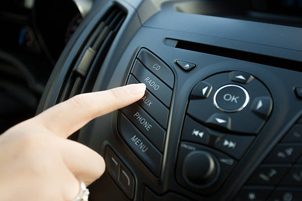 istock woman pressing radio button on car dashboard 525340890