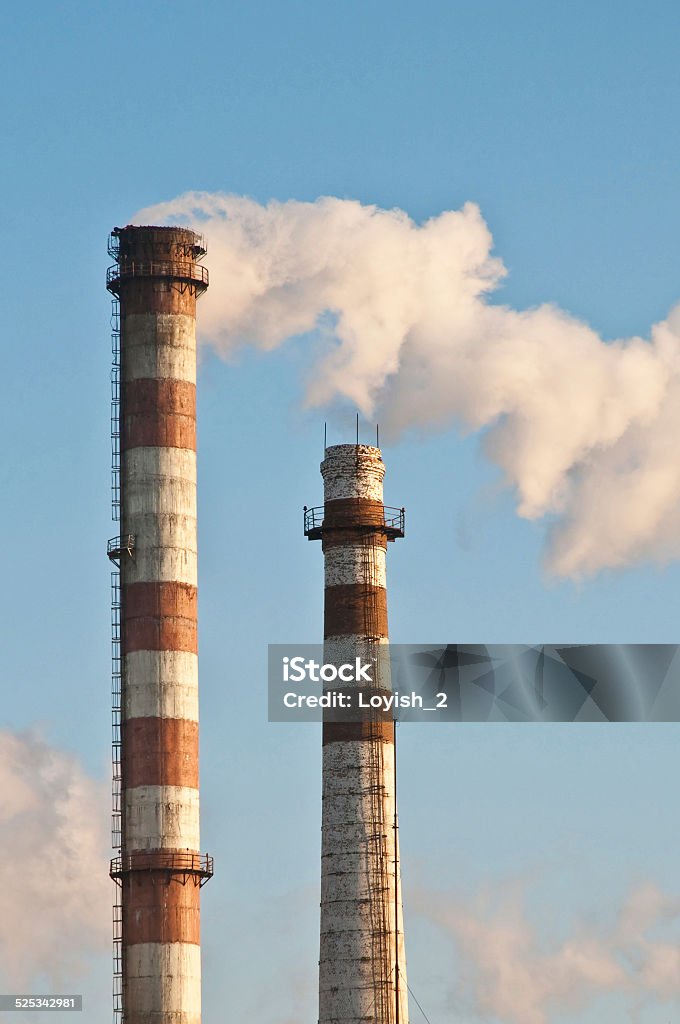 Two pipes and smoke Two pipes and smoke on blue sky background Blue Stock Photo