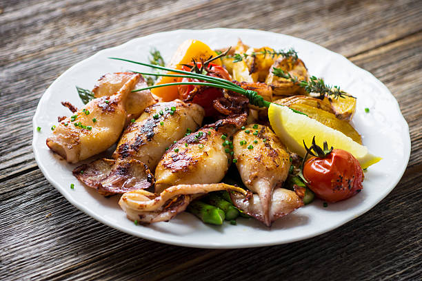 grilled squids with asparagus and potato - dinner croatia bildbanksfoton och bilder