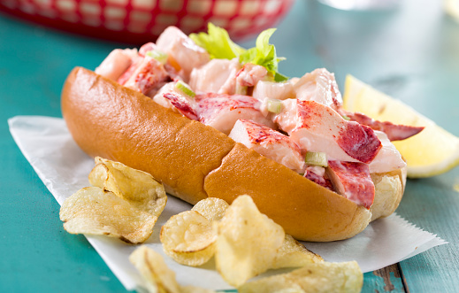 A fresh made Maine / New England lobster roll with mayonnaise, celery, butter, and lemon with a side of chips.  Please see my portfolio for other food and drink images. 