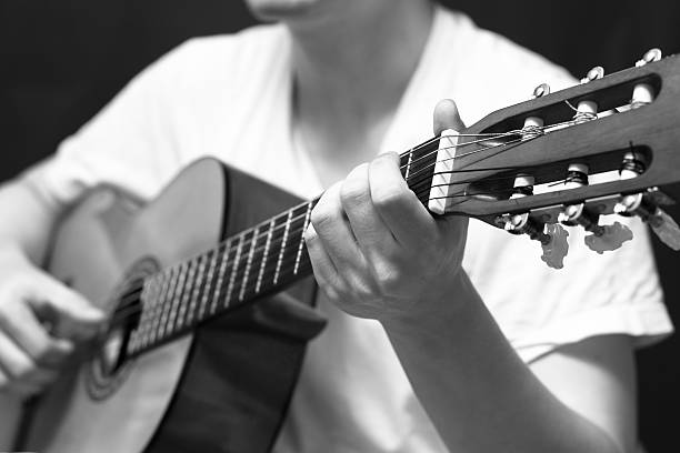 istock musician plays acoustic, classical guitar 525344519