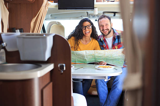 istock Cheerful couple using map inside of a camper van 525345692