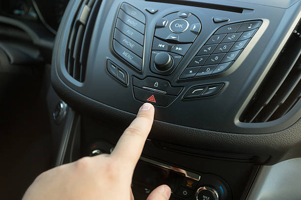 istock Closeup of driver pressing emergency button on car dashboard 525346794