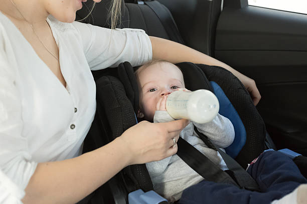 istock little boy drinking milk from bottle on car back seat 525347164
