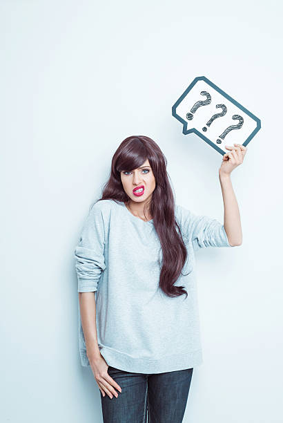 joven mujer sosteniendo globo de diálogo con el llamado interrogante - thought bubble speech bubble decisions thinking fotografías e imágenes de stock