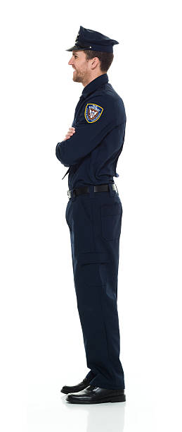 istock Smiling police standing with arms crossed 525349168