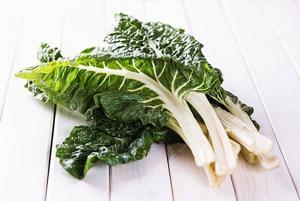Bunch of silverbeet on a white wooden table stock photo
