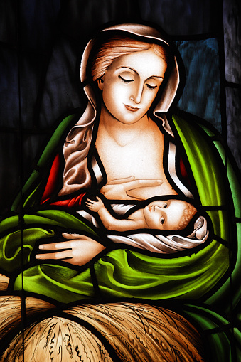 Baby Jesus and Mother Mary depicted in a stained glass window.