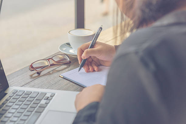Looking from back of woman taking note without wearing glasses stock photo