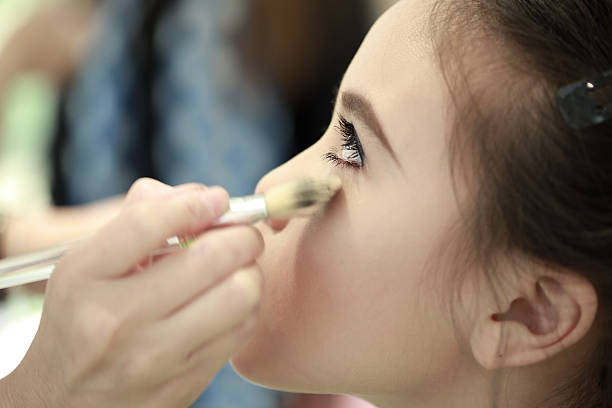 istock Little girl applying make up. 525355257