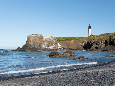 Cobble Beach, with Yaquina Head lighthouse in the background; near Newport, Oregon.