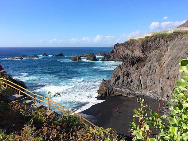 spiaggia vulcanica nera tra alta rocks - sky travel destinations tourism canary islands foto e immagini stock
