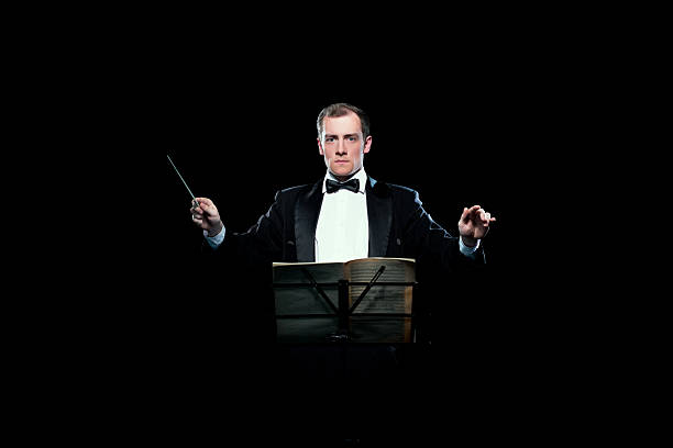 Studio photo of music conductor holding his baton Studio photo of male music conductor holding his baton musical conductor stock pictures, royalty-free photos & images