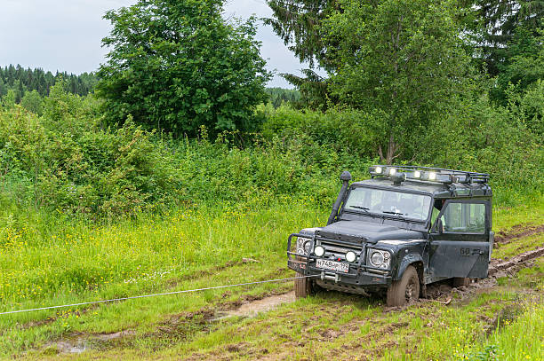 funcionamento do guincho de terra rover defesa veículo afundado na lama - mud dirt road road dirt imagens e fotografias de stock
