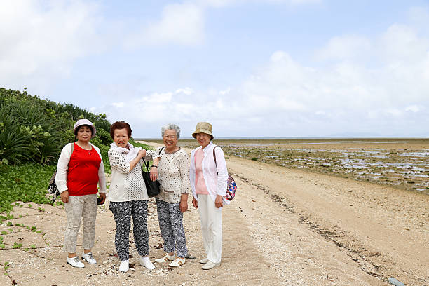 Elderly woman standing on the beach