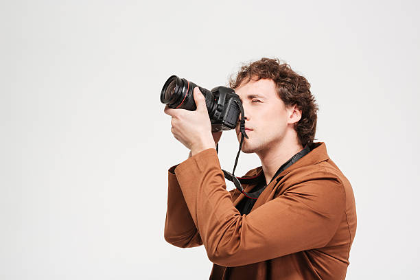 istock Young man photographing on professional camera 525367320