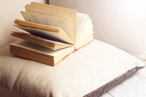 istock Open book on a pillow in bed. homeliness. 525367400