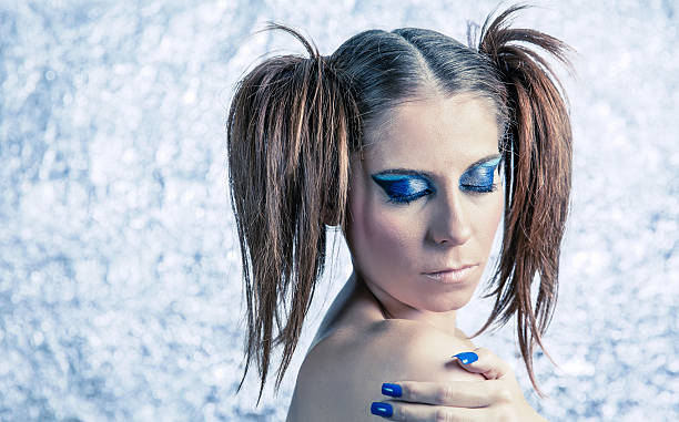 istock Beautiful model with pigtails, fancy makeup and blue manicure 525369025
