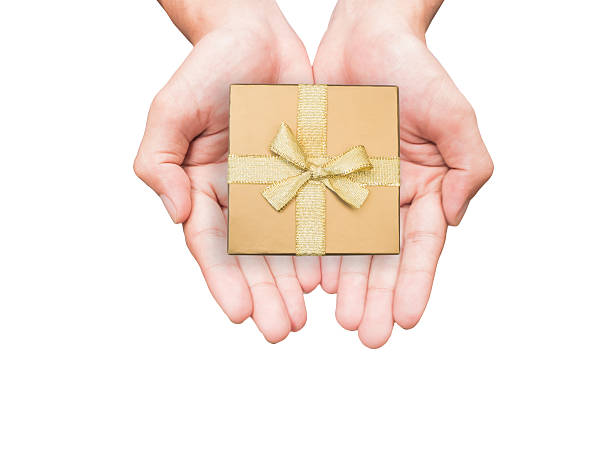 istock Hand holding golden gift box isolated 525369041