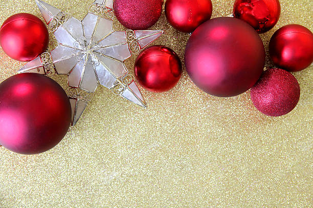istock Christmas Bulbs and Star Tree Topper Framing Gold Glitter Backgr 525380847