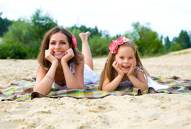 istock Mother and daughter having a rest on a beach 525383019