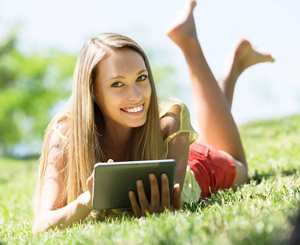 istock Girl relaxing outdoor with tablet 525383075