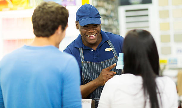 istock shop assistant helping couple choose paint color at hardware store 525383157
