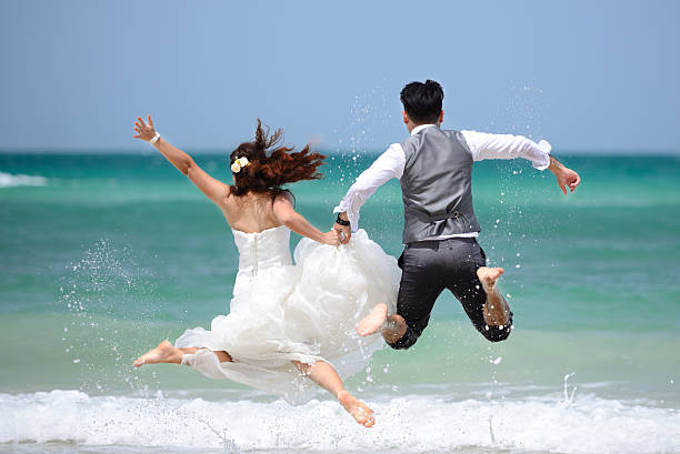 若いカップルで結婚記念と楽しいひとときを - wedding beach groom bride ストックフォトと画像