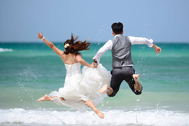 właśnie żonaty młoda para świętować i baw się dobrze - wedding beach bride groom zdjęcia i obrazy z banku zdjęć