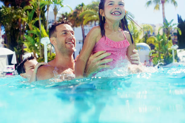 istock Father with daughter and son playing in swimming pool 525409229