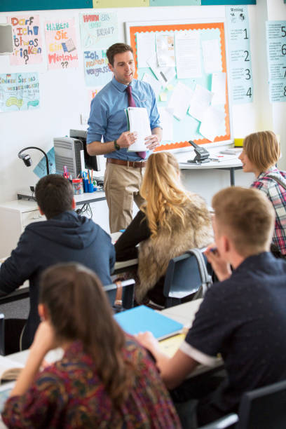 Teacher talking to teenage students in classroom  high school teacher stock pictures, royalty-free photos & images