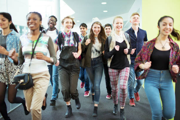 istock Group of cheerful students running in corridor 525409647
