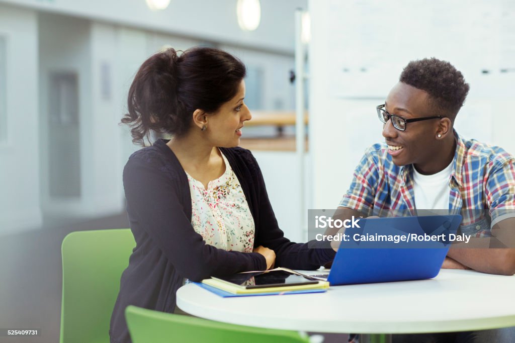 Teacher and student sitting together with laptop and tablet  Advice Stock Photo