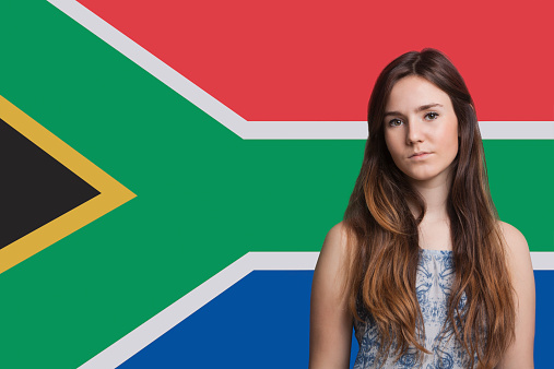 Portrait of young woman against South African flag