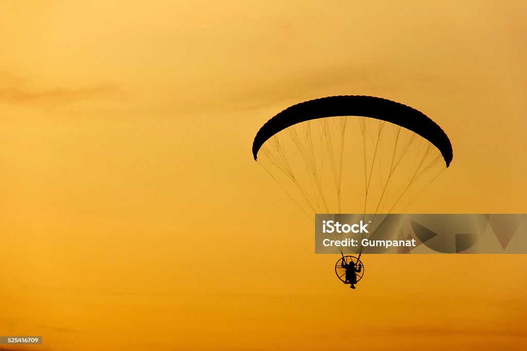 paramotor / paraglider flying into sunset sky Abstract Stock Photo