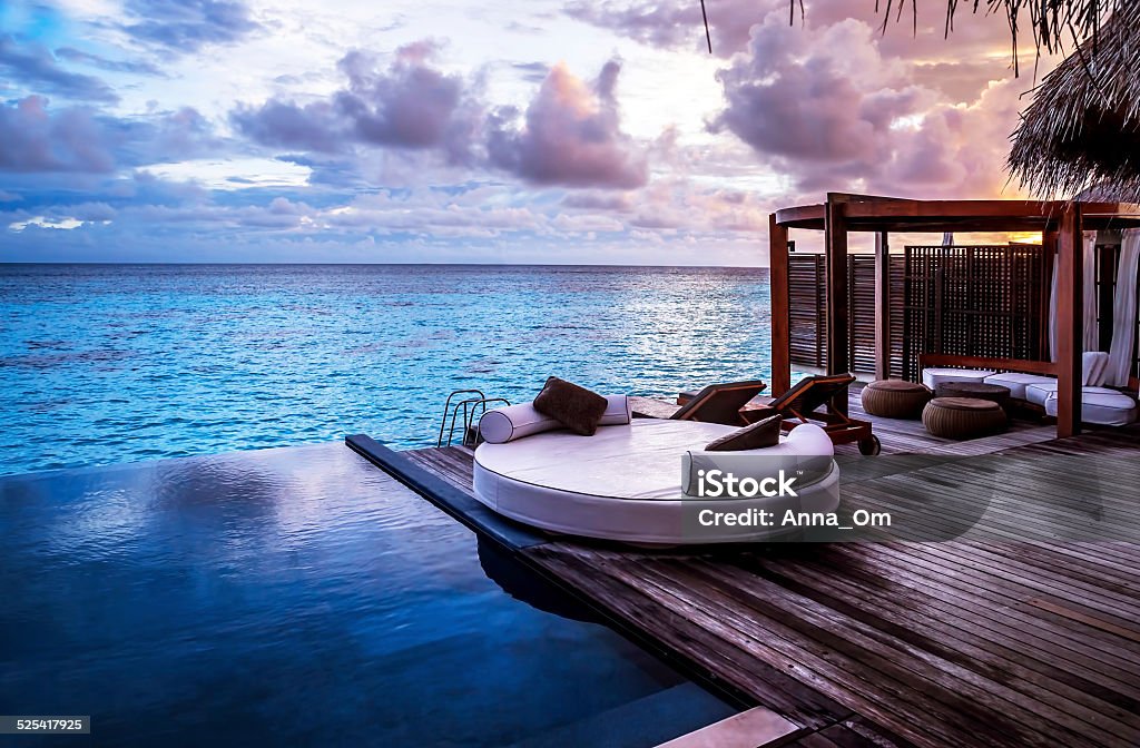 Luxury beach resort Luxury beach resort, bungalow near endless pool over sea sunset, evening on tropical island, summer vacation concept Maldives Stock Photo