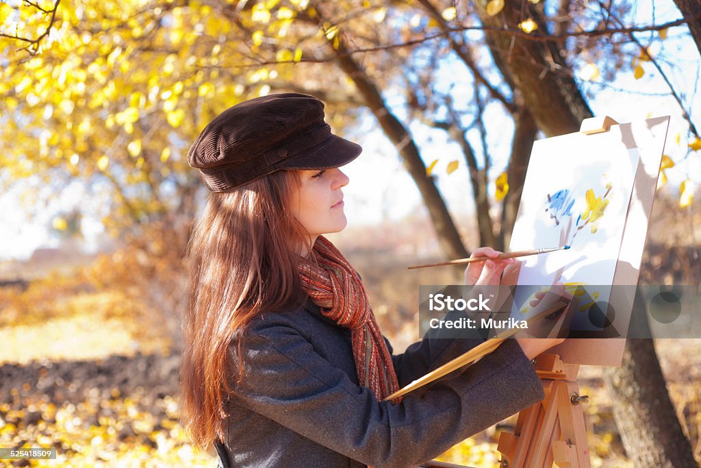 The girl is engaged in painting on nature Adult Stock Photo