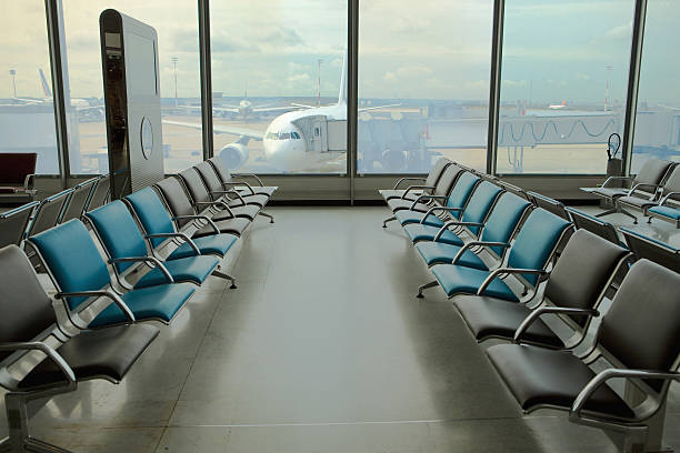 istock Can see empty armchairs at  airport and plane through glass 525421625