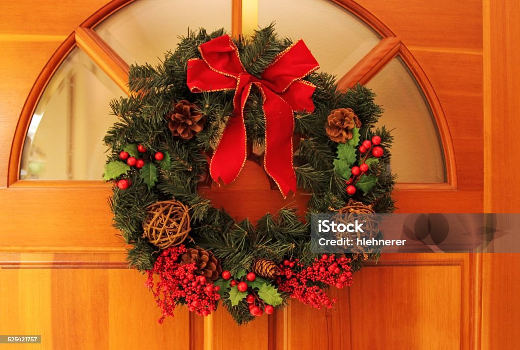 Christmas Wreaths Christams wreaths hanging on a wooden entrance door. Berry Stock Photo